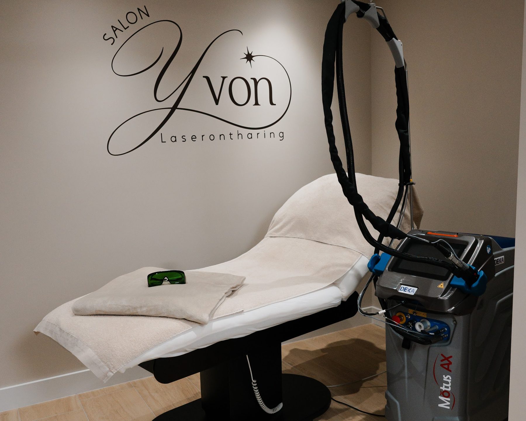 De laserkamer van Salon Yvon met de DEKA Motus AX en het logo op de muur
