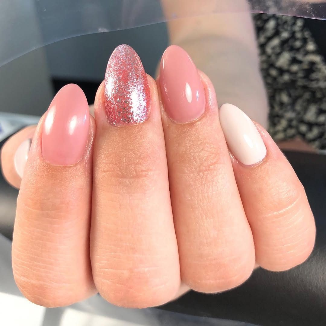 Amandelvormige nagels in zacht roze met één glitternagel